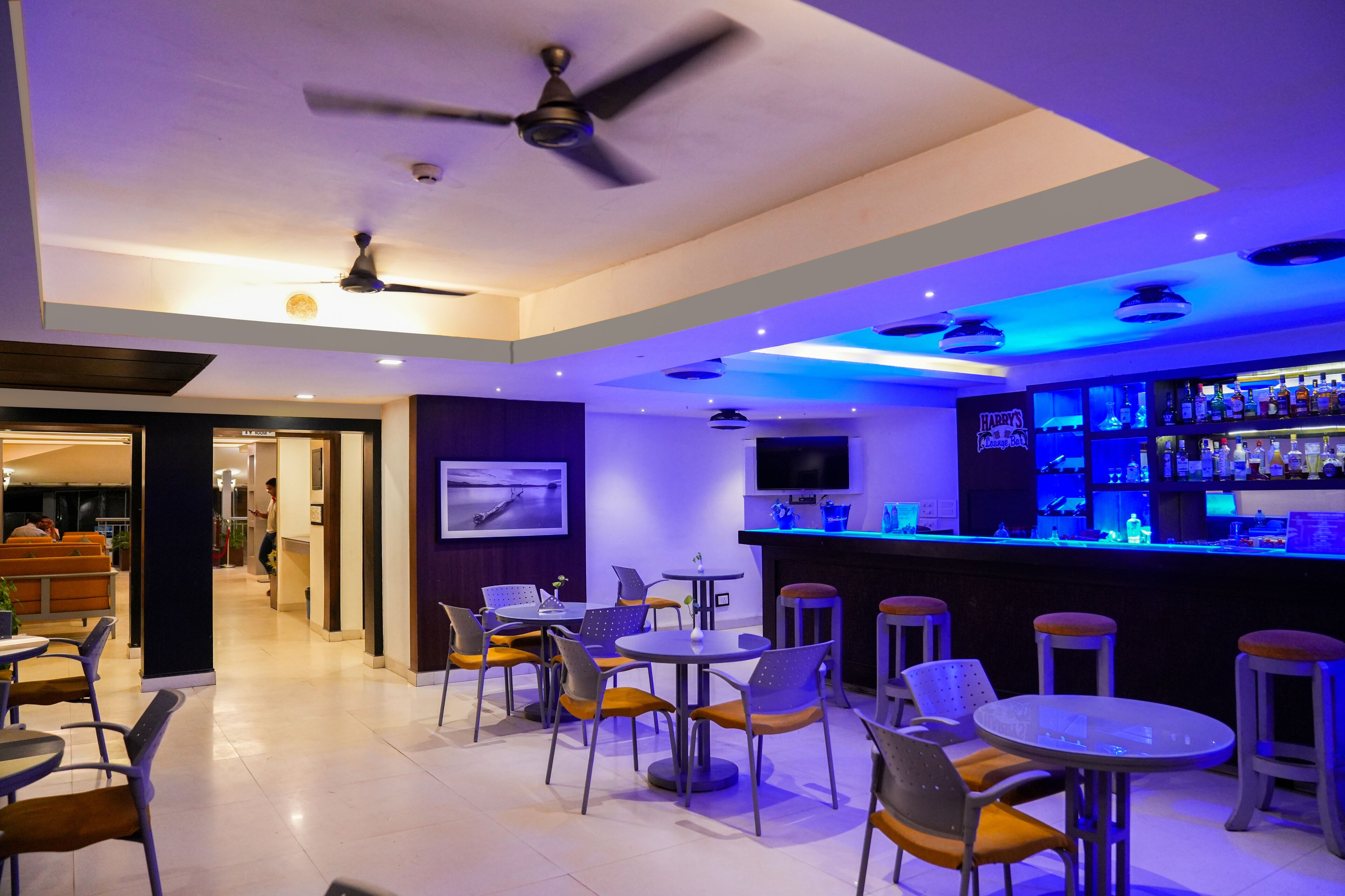 Un bar con asientos y una pantalla de televisión.