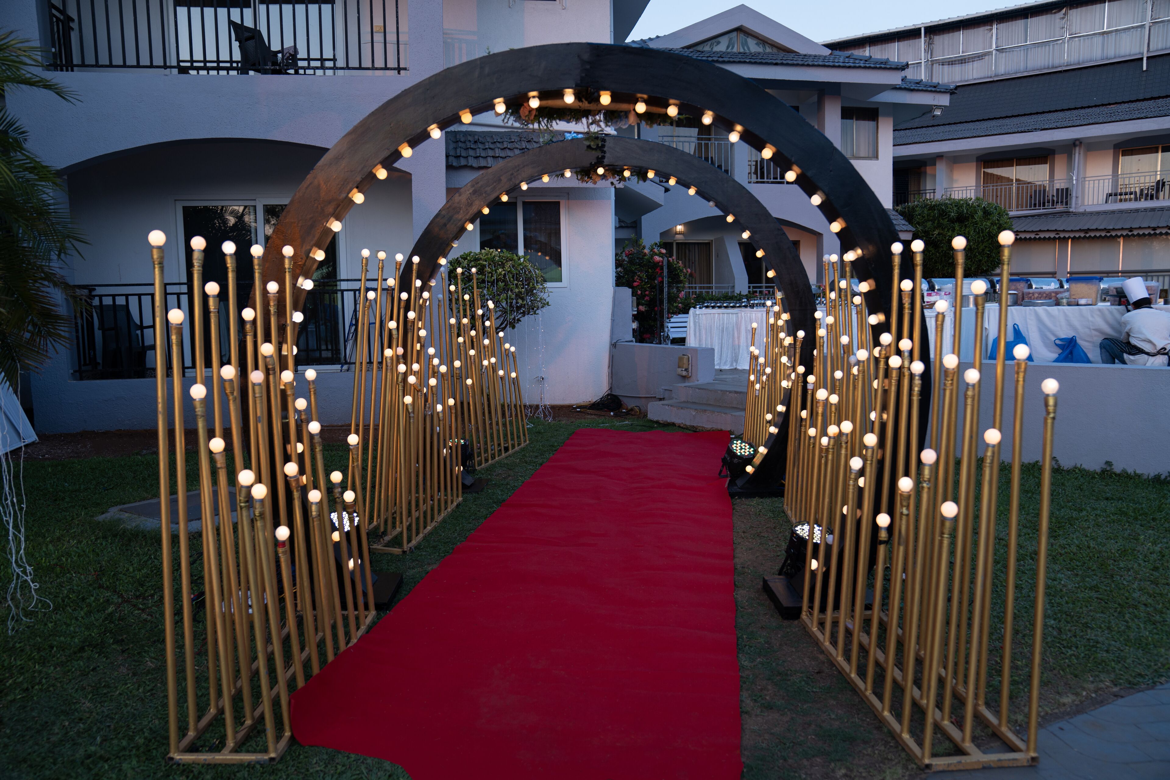 A red carpet leading through an arched entrance with decorative light fixtures.