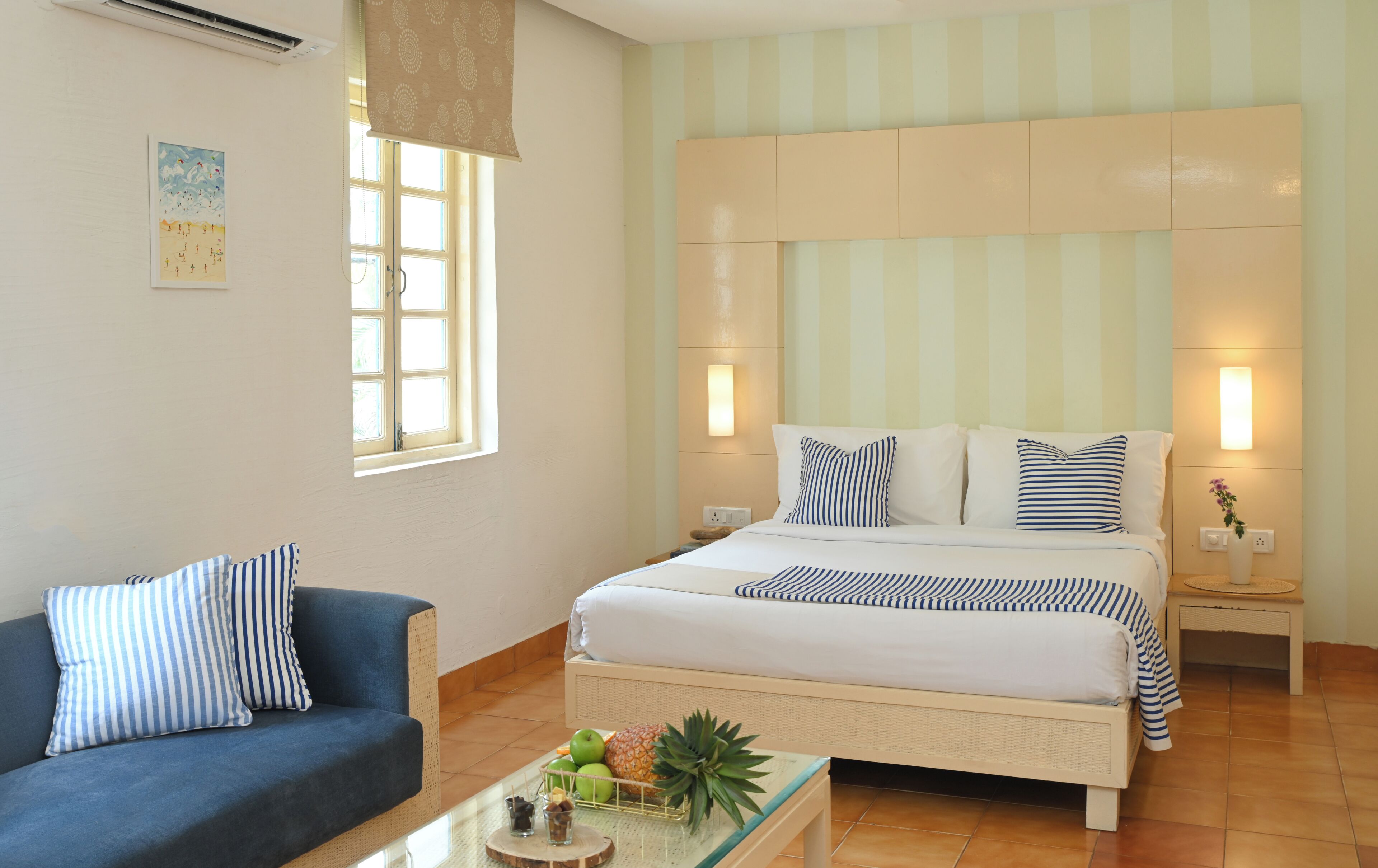Un dormitorio con cama, sofá, ventana y luz empotrada.