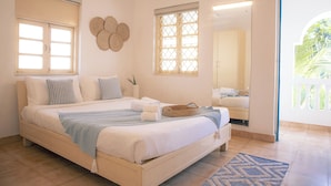 A bedroom with a bed, a window, a mirror, and a door leading to a balcony. - Soul Vacation Resort and Spa, Colva (Colva)