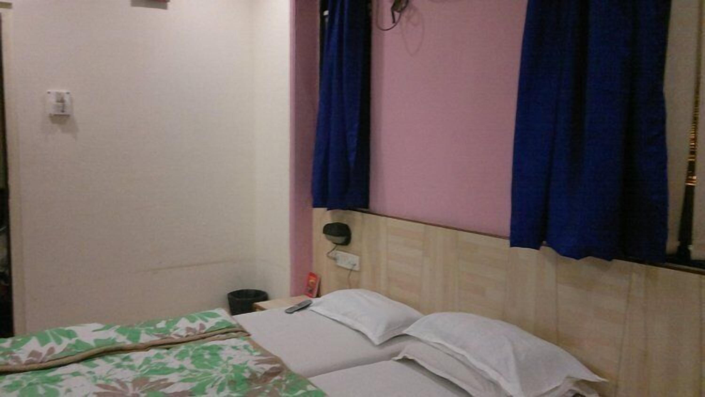 Una habitación pequeña y sencilla con una cama, un calentador en la pared y una puerta.