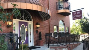 A brick building with a purple door, a balcony, and a sign reading "Old Town Guesthouse Bed & Breakfast." - Old Town GuestHouse B&B (Colorado Springs)