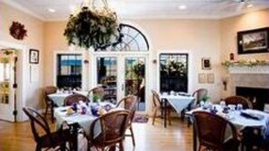 A dining area with tables set for a meal, wooden chairs, and a chandelier. - Old Town GuestHouse B&B (Colorado Springs)