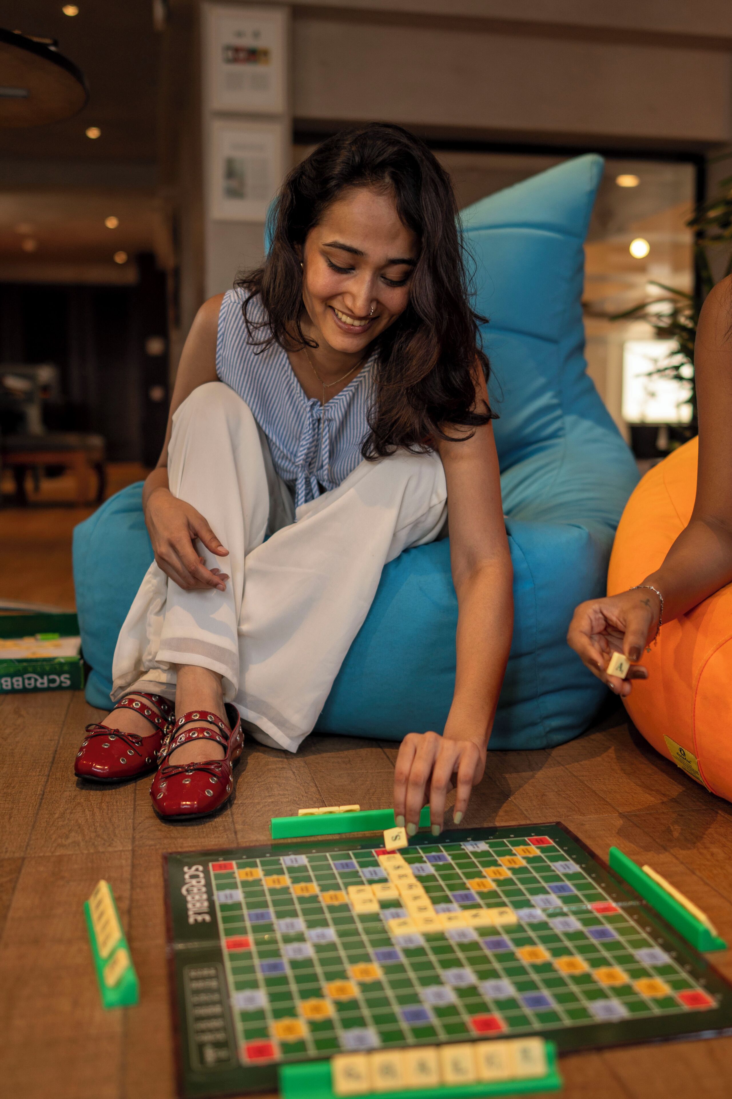 A person sitting on a blue couch playing a board game.