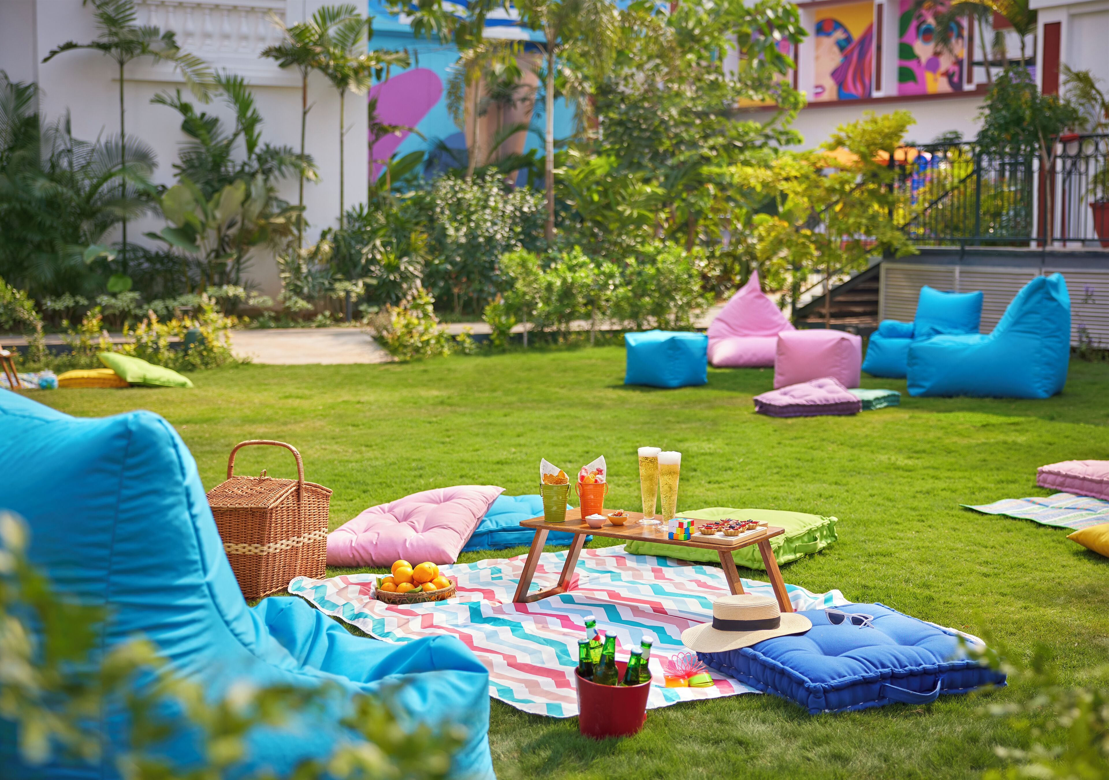 Un espacio de patio al aire libre con mesas, sillas y cojines para un picnic.