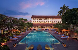 Una gran piscina interior con varias zonas de estar y un bar.