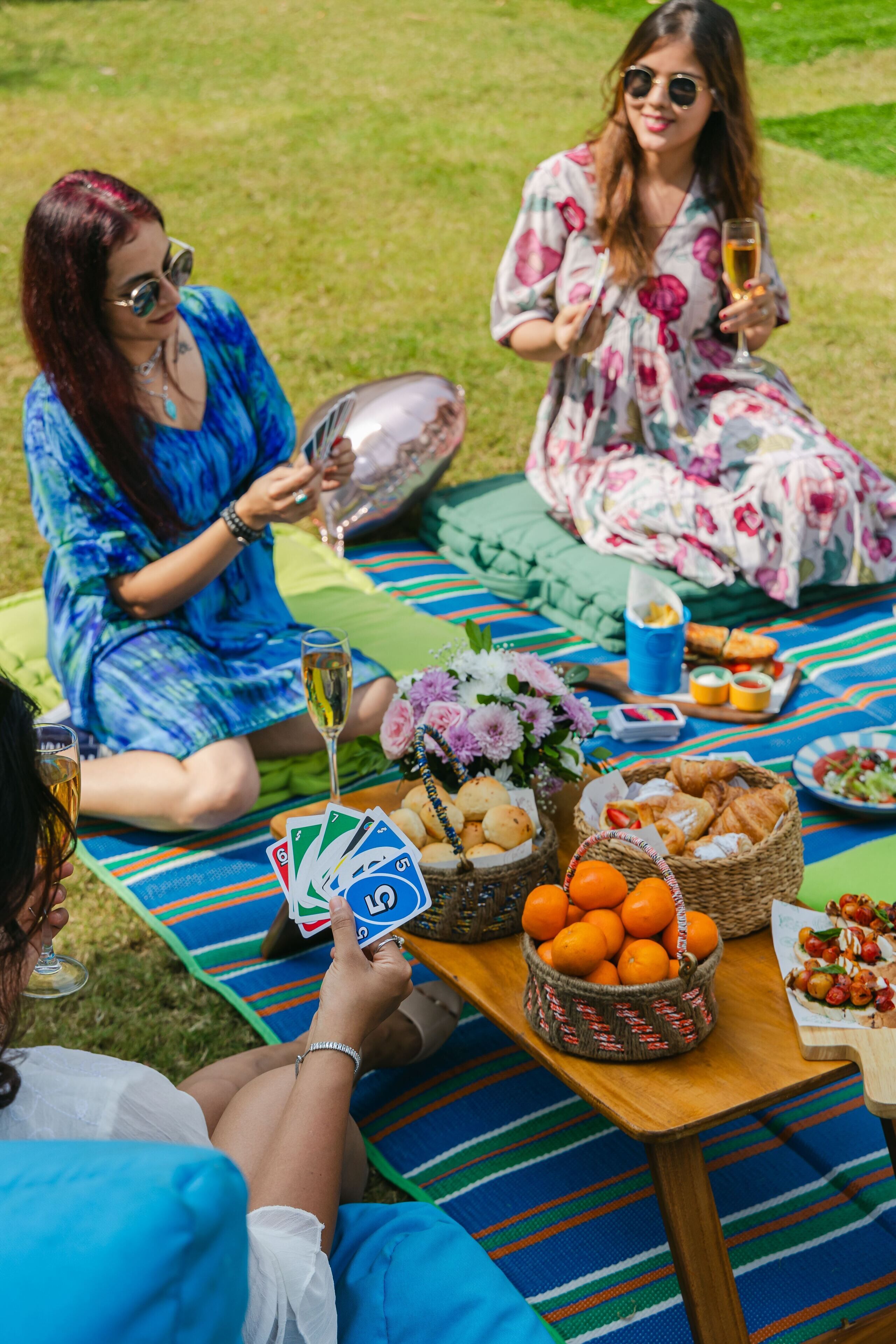 A picnic setup with a table, blankets, and food items.