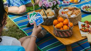 A picnic setup with a table, blankets, and food items.