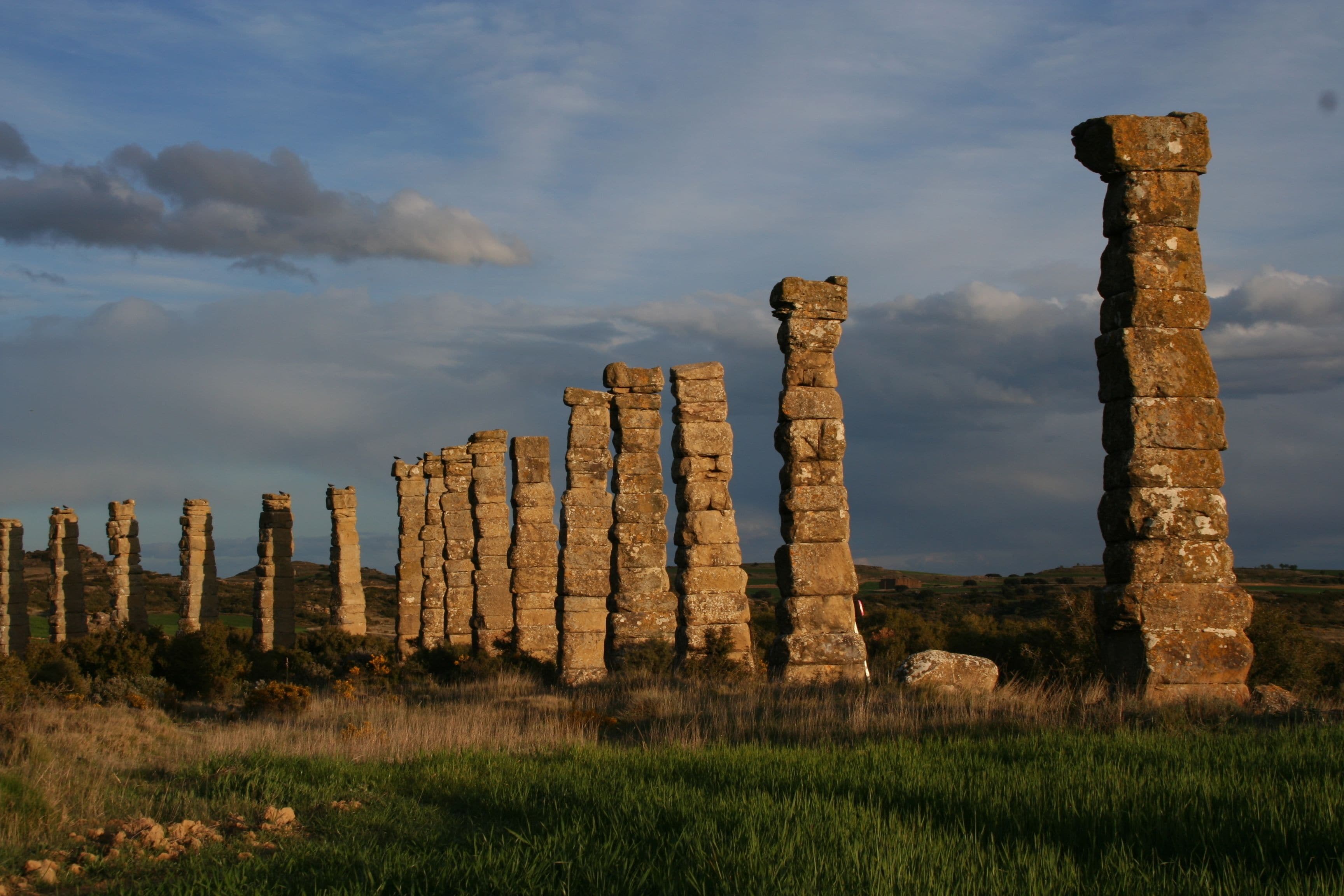 Una serie de pilares de piedra en un campo cubierto de hierba.