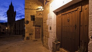 Un edificio de piedra con una puerta de madera grande, un letrero que dice "Pastora FOSADA" y un reloj.