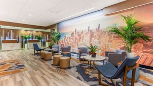A hotel lobby with a reception desk, seating area, and a mural of a city skyline. - La Quinta Inn & Suites by Wyndham Chicago Downtown (Chicago)
