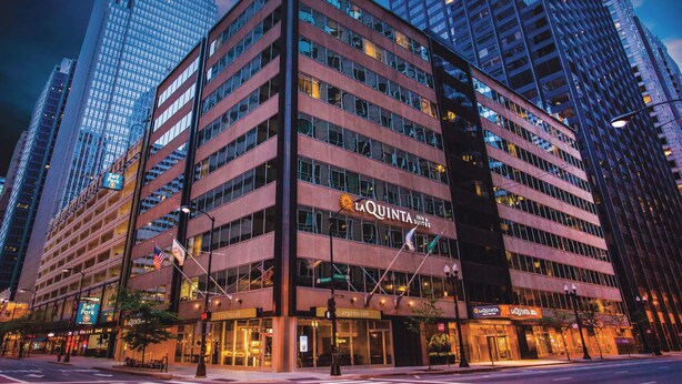 A multi-story hotel with a prominent 'La Quinta' sign, featuring a modern architectural design with large windows and a flat facade. - La Quinta Inn & Suites by Wyndham Chicago Downtown (Chicago)