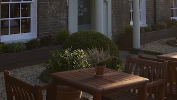 El Feathers Inn, un edificio de ladrillo tradicional con letrero, zona de asientos al aire libre y farola.