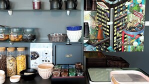 Un piano di lavoro in cucina con barattoli, ciotole e una macchina per il caffè.