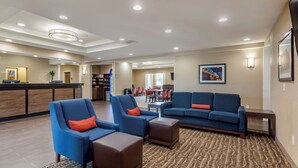 A hotel lobby with seating areas, a reception desk, and a dining area. - Comfort Suites Clarksville near Governors Square Mall (Clarksville)
