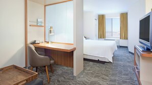 A hotel room with a desk, chair, bed, television, and a window with curtains. - SpringHill Suites by Marriott Wichita East at Plazzio (Wichita)