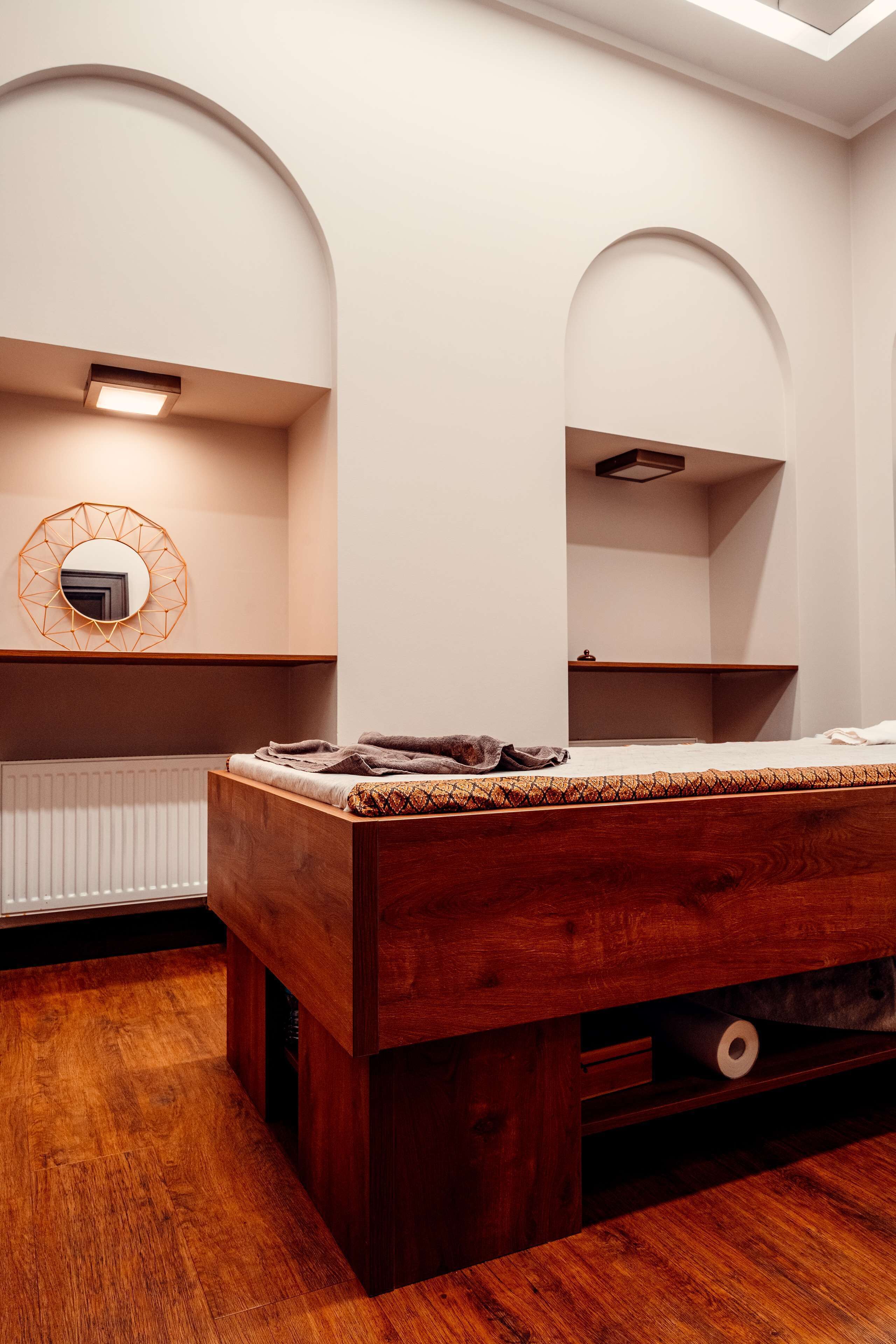 A bedroom with a wooden bed, a white radiator, and a mirror on the wall.