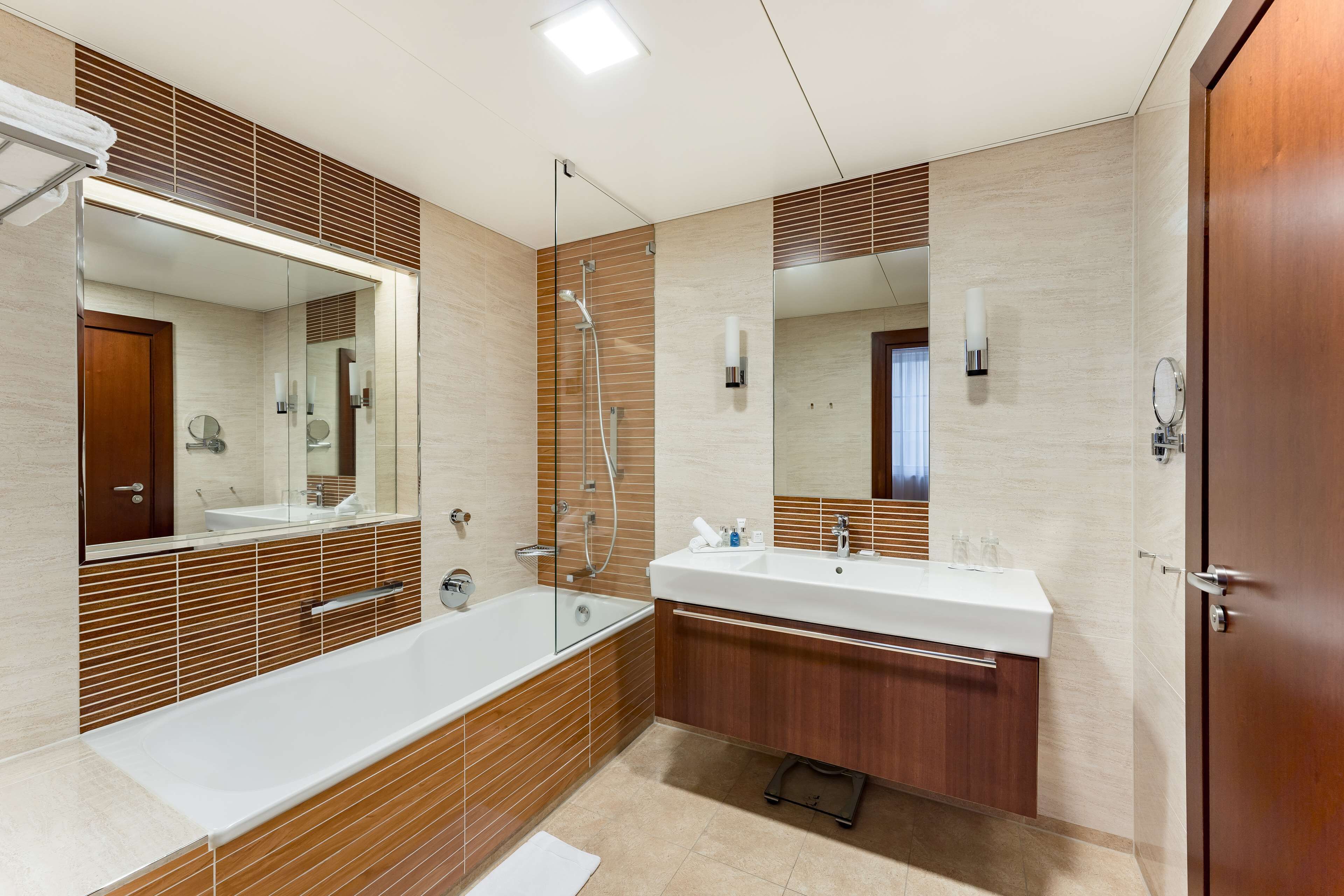 Un baño moderno con una bañera grande, un lavamanos doble y una ducha a ras de suelo.