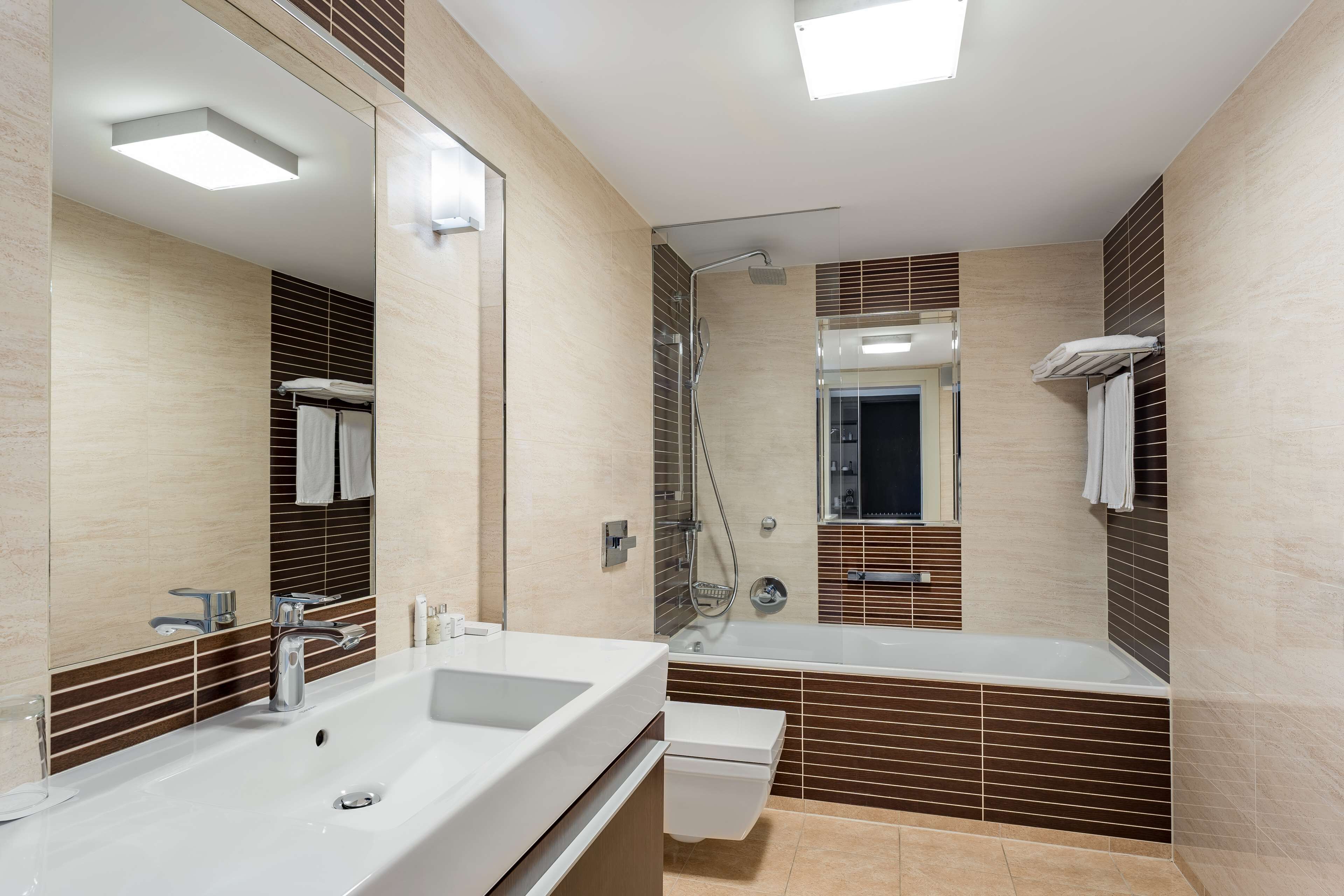 Un baño moderno con un lavamanos grande, una bañera y una zona de ducha.