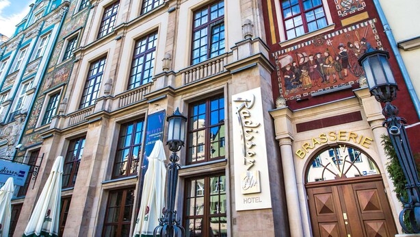 A historic building with a prominent hotel sign, large windows, and a detailed facade.