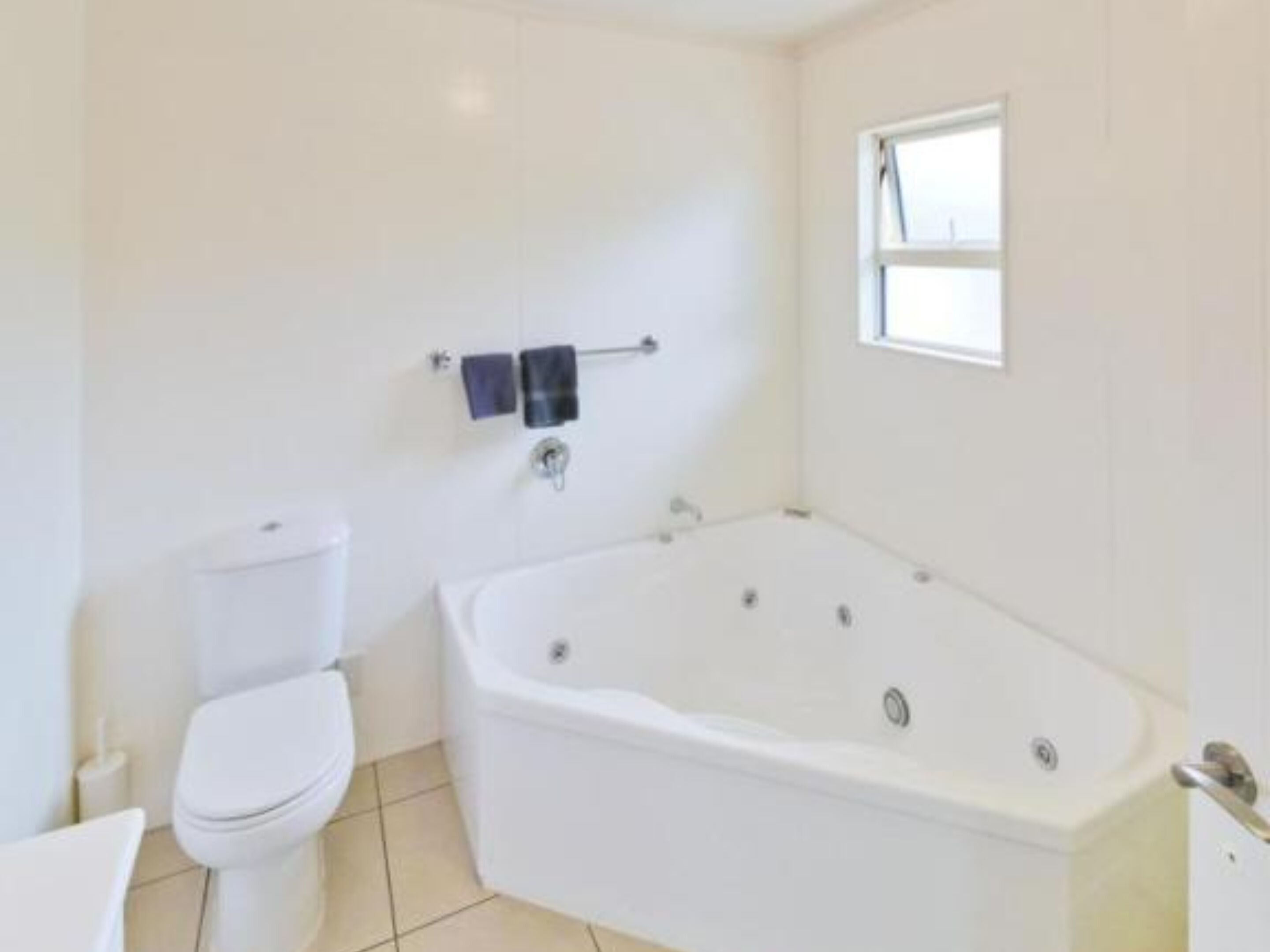 Un bagno con una vasca da bagno bianca, un water e un lavandino.