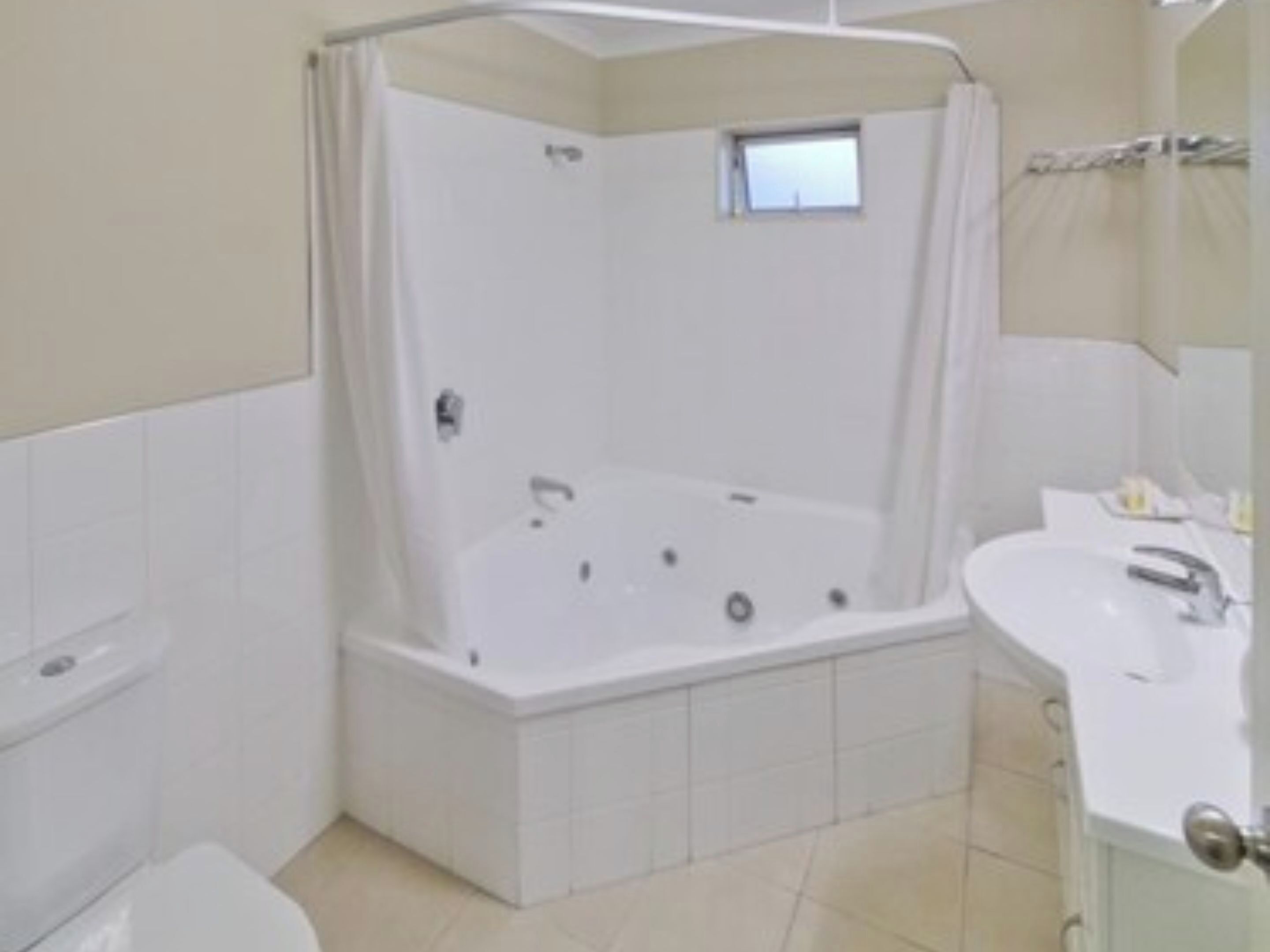 A bathroom with a bathtub, toilet, and sink.