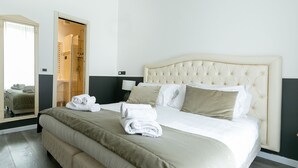 A hotel room with a large bed, a walk-in closet, and a view of the city. - Capitolium Rooms (Rome)