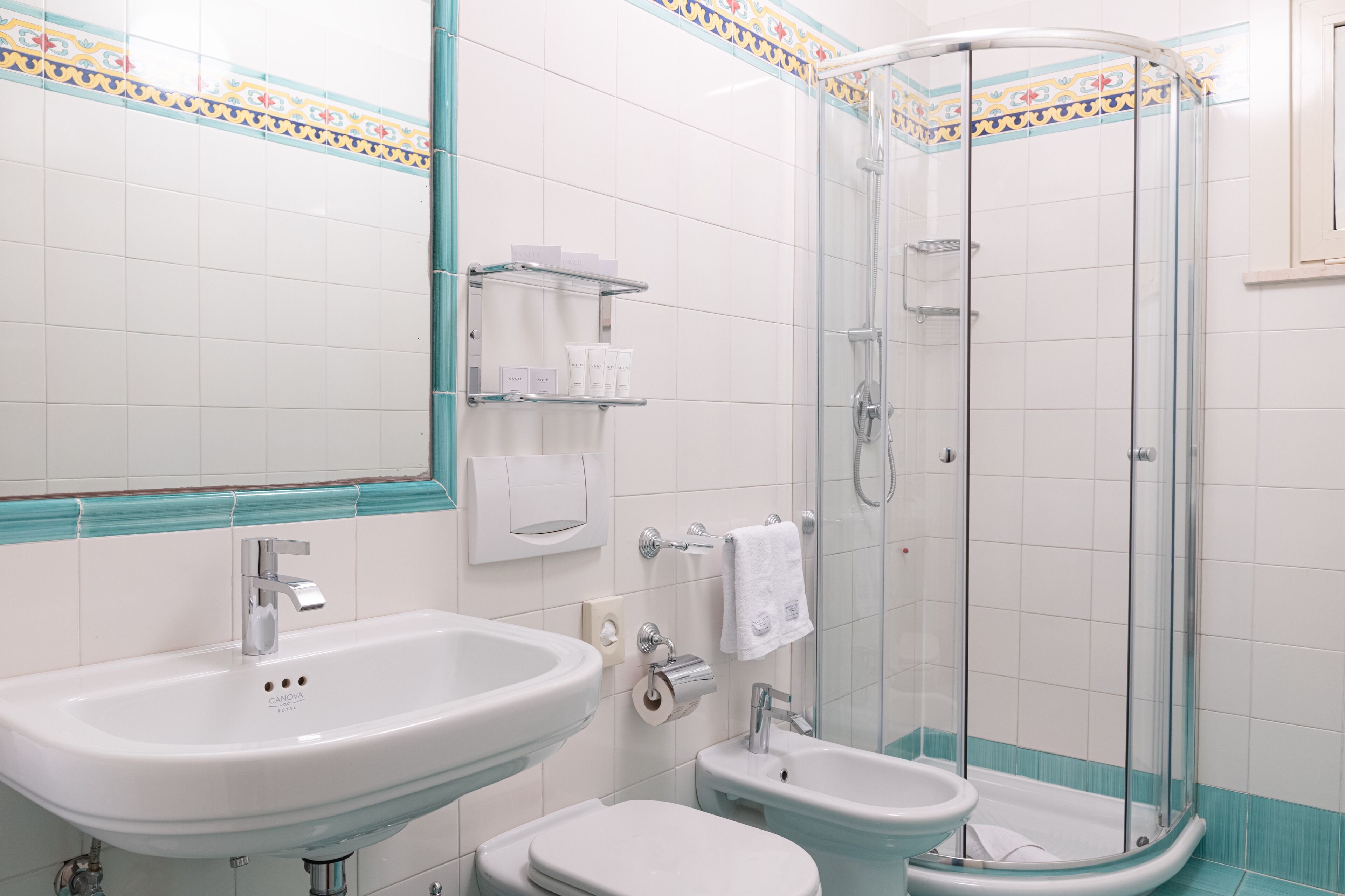 A bathroom with a large sink, a toilet, and a glass-enclosed shower.