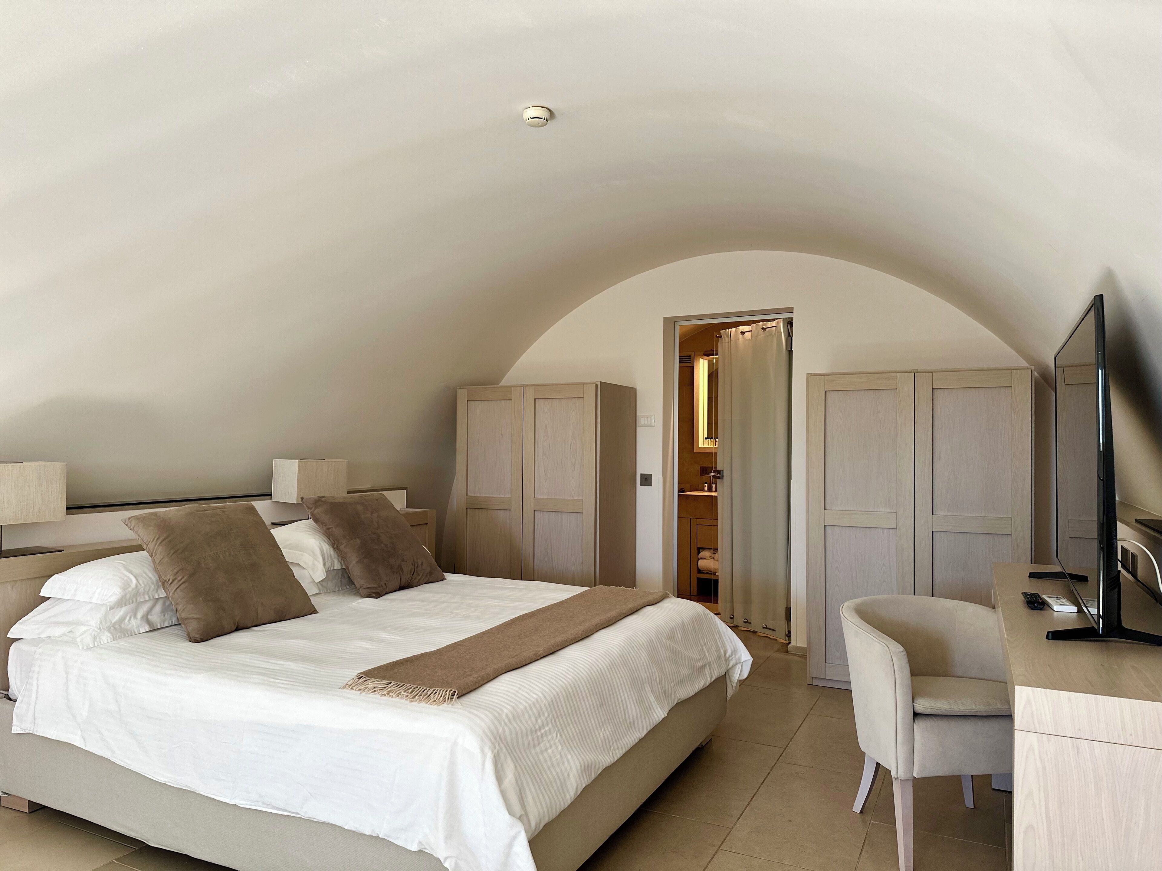 Una camera da letto con un letto grande, una scrivania con una sedia e un armadio.