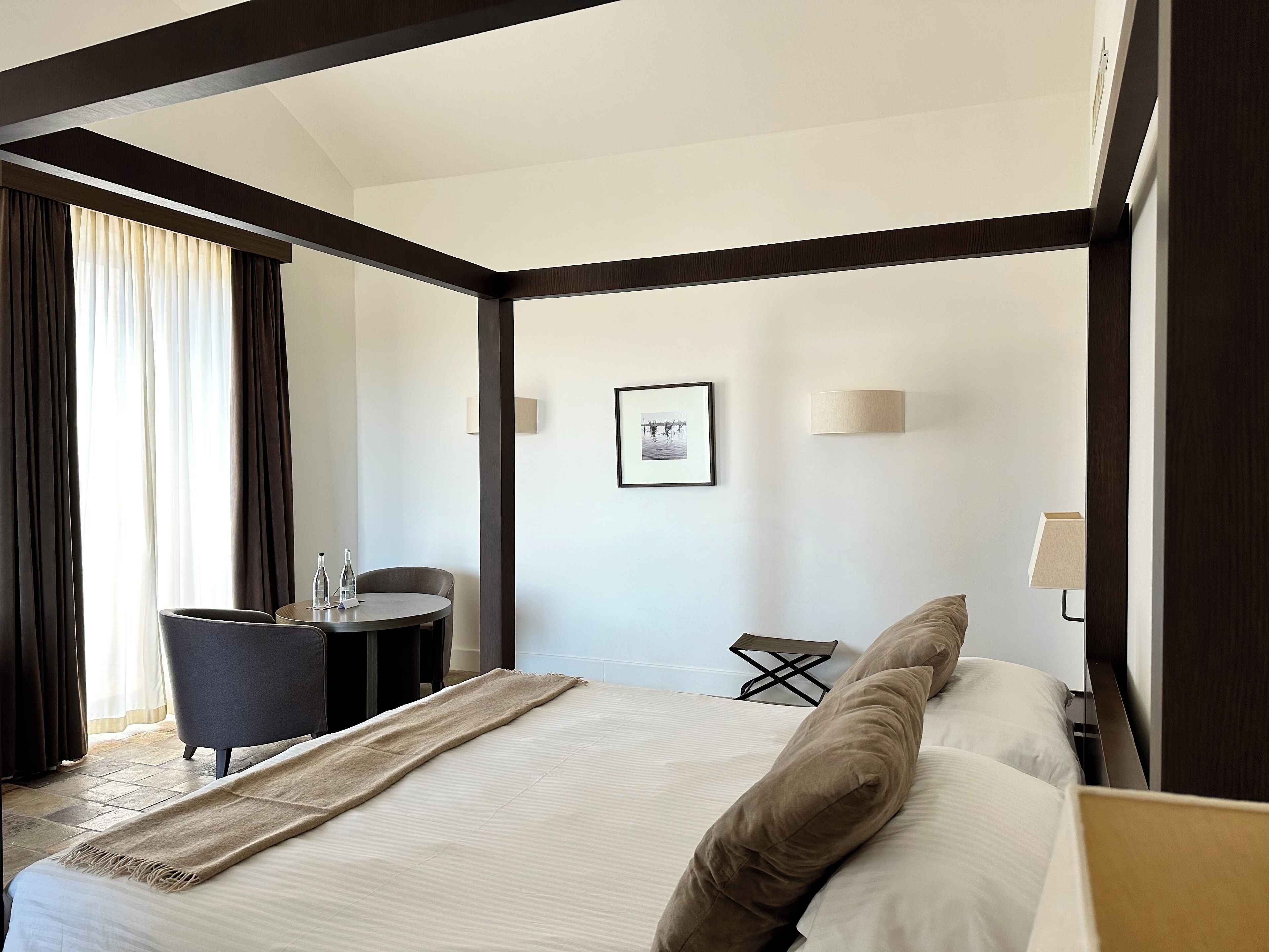 Una camera d'albergo moderna con un letto grande, una scrivania e una poltrona.