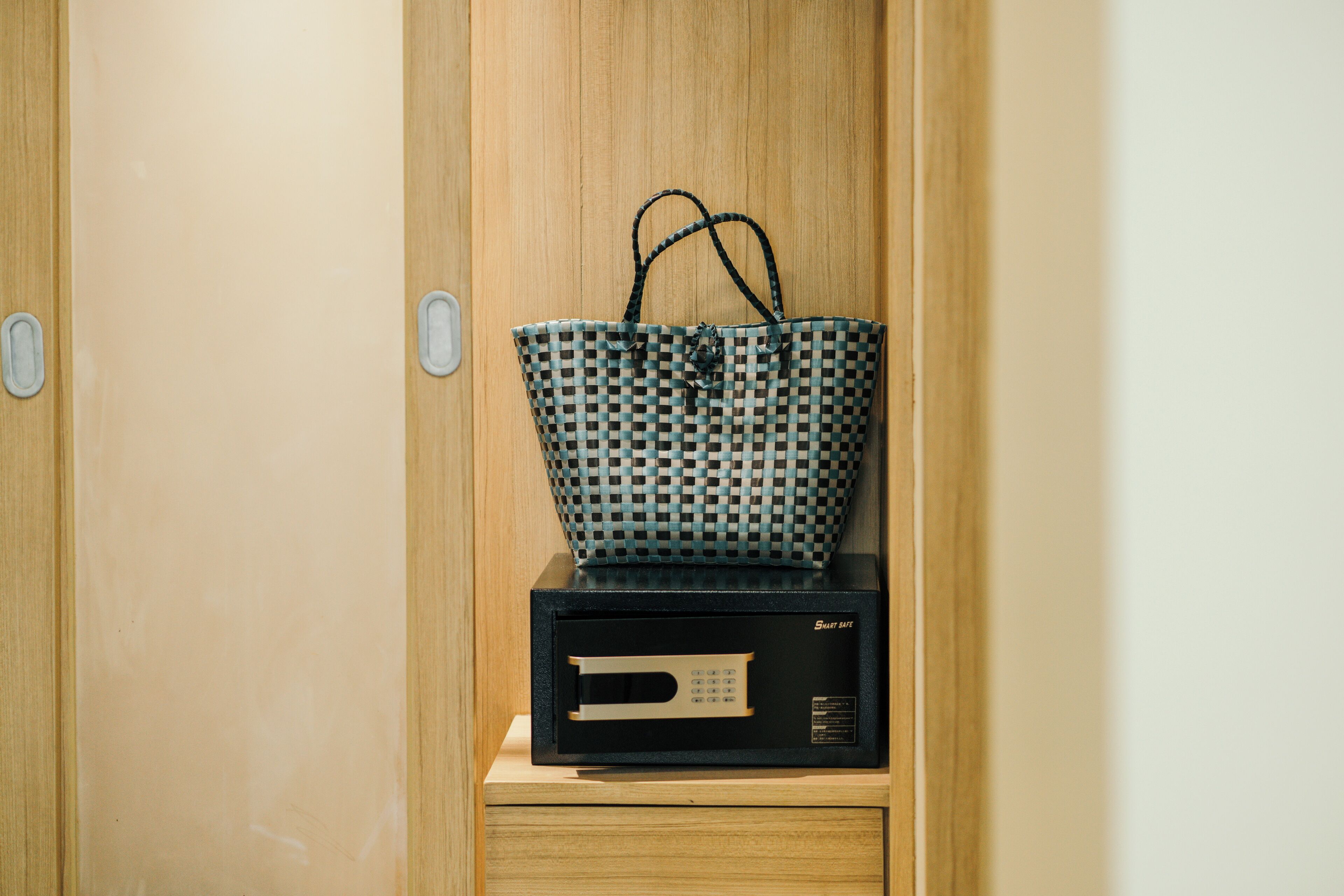 A wooden wardrobe with a black electronic device on top.