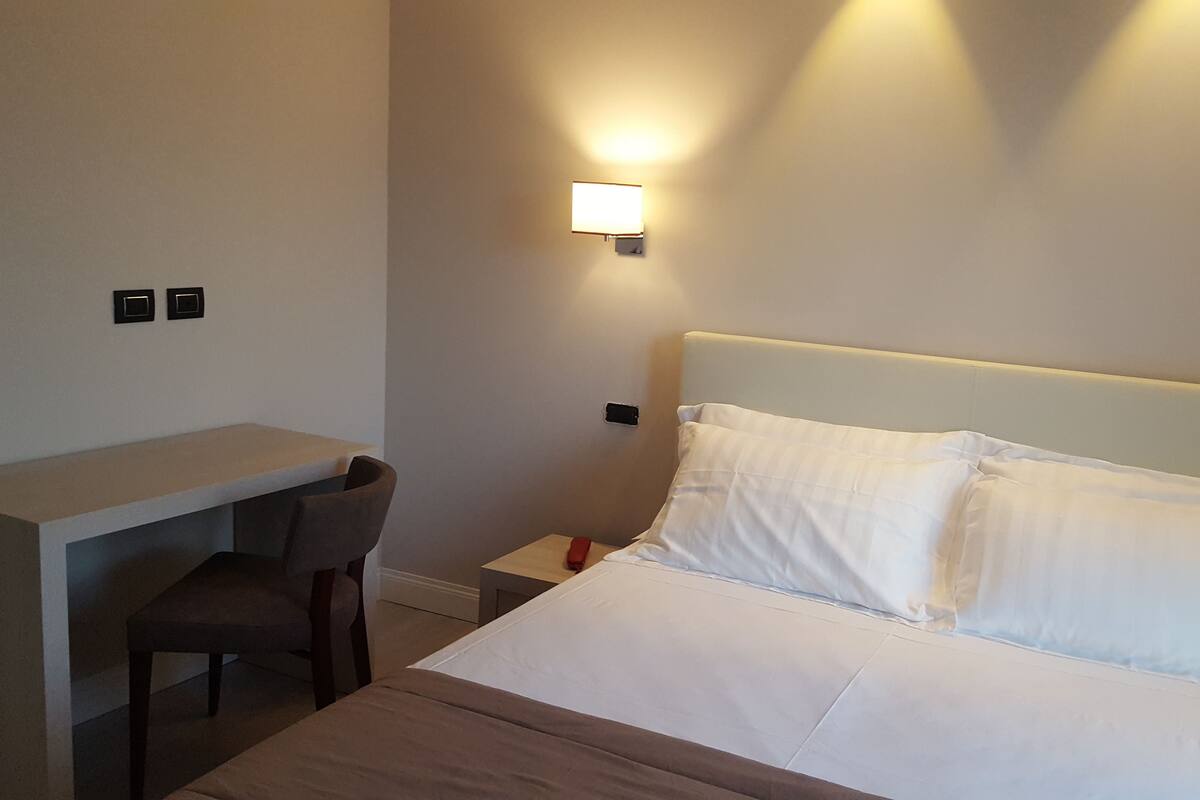 Ein Hotelzimmer mit Bett, Schreibtisch und Stuhl.