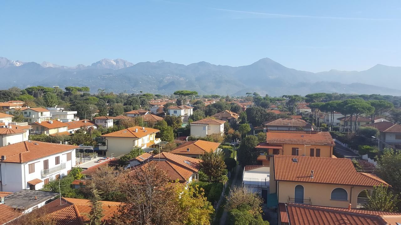 Zona residencial con casas, algunas con tejados de tejas rojas, y una cordillera al fondo.