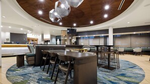A modern hotel lobby with a central bar, seating area, and a reception desk. - SpringHill Suites by Marriott McAllen Convention Center (McAllen)