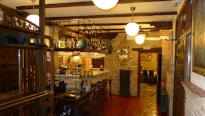 A bar area with wooden furniture, a stone wall, and a sign reading "SALIDA".