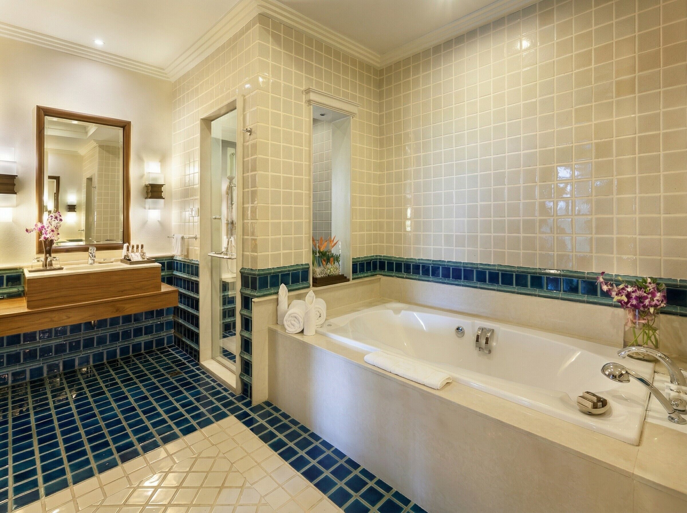 Un baño con bañera, espejo, lavabo y zona de ducha.