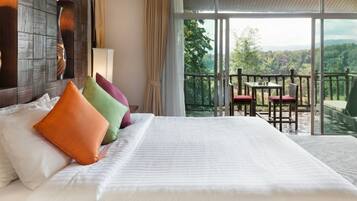 A hotel room with a large bed, a balcony with a table and chairs, and a view of the outdoors.