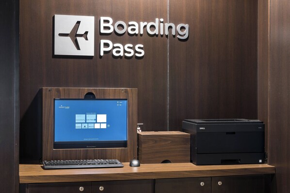 A desk with a computer, a printer, and a sign that reads "Boarding Pass". - Courtyard by Marriott Austin Parmer/Tech Ridge (Austin)