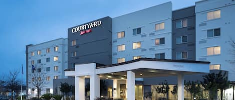 Un hotel Courtyard Marriott con entrada cubierta, varios pisos y horario de estacionamiento de 12 a 6 horas.
