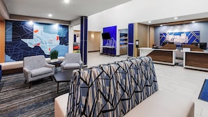 A modern lobby with seating areas, a reception desk, and a large abstract wall mural. - Holiday Inn Express and Suites Henderson by IHG (Henderson)