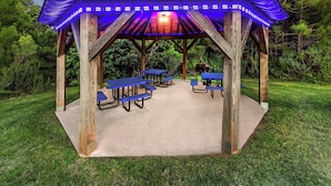 A wooden gazebo with blue benches and a solar panel roof. - Holiday Inn Express and Suites Henderson by IHG (Henderson)