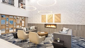 Een moderne lounge met een open haard, comfortabele zitplaatsen en decoratieve wandpanelen.