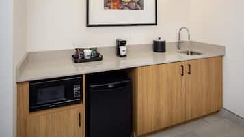A compact kitchen with a microwave, dishwasher, coffee maker, and sink.