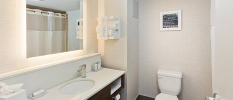 Un baño moderno con un espejo grande, dos lavamanos, un inodoro y una cortina de ducha.