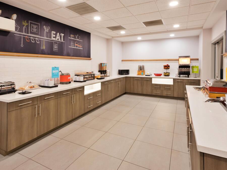 Una cocina moderna con una pared de pizarra, una cafetera y una variedad de electrodomésticos.