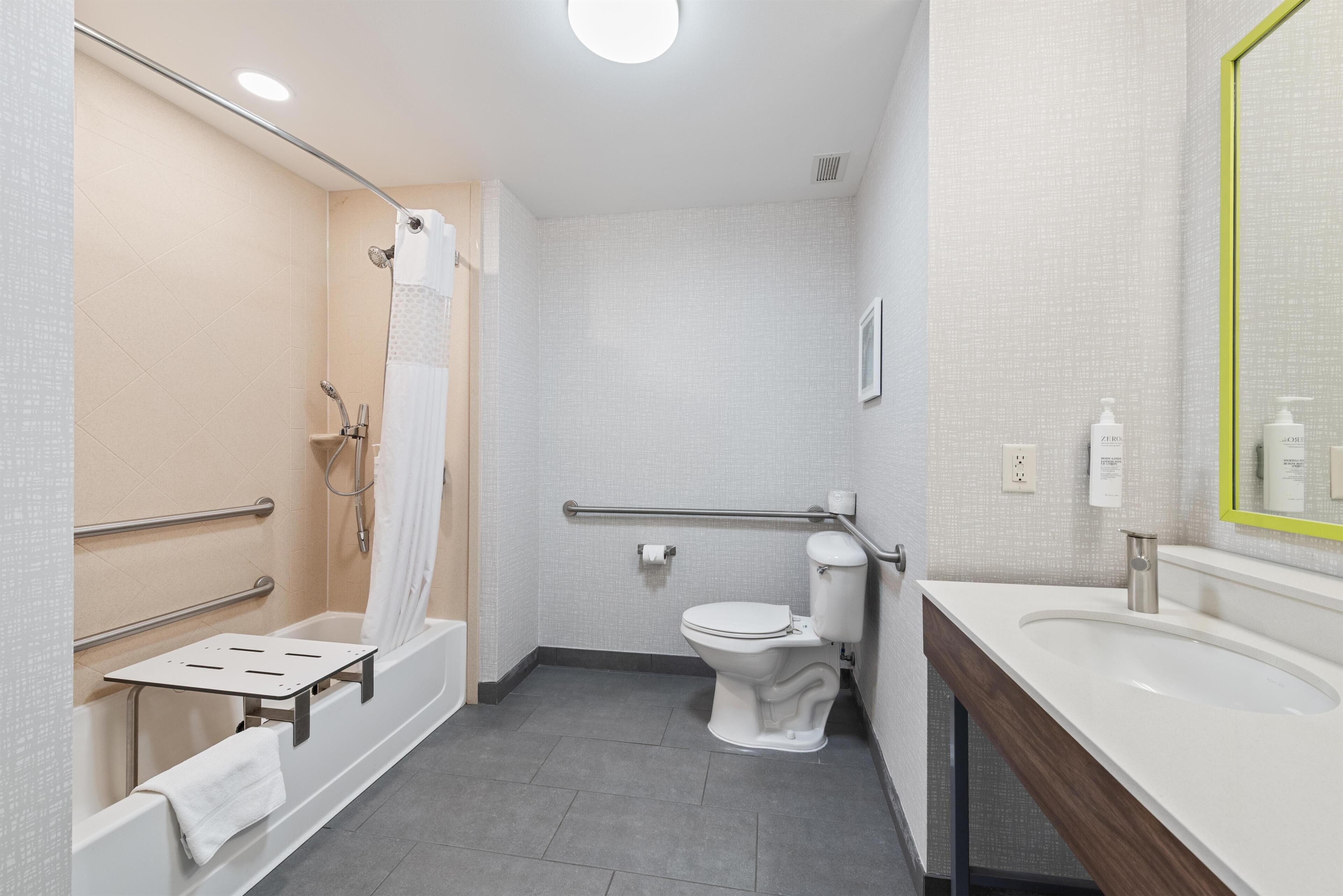 A modern bathroom with a bathtub, shower, toilet, and sink.