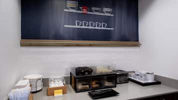Un área de desayuno con un menú en una pizarra, un tostador y una presentación de huevos duros.