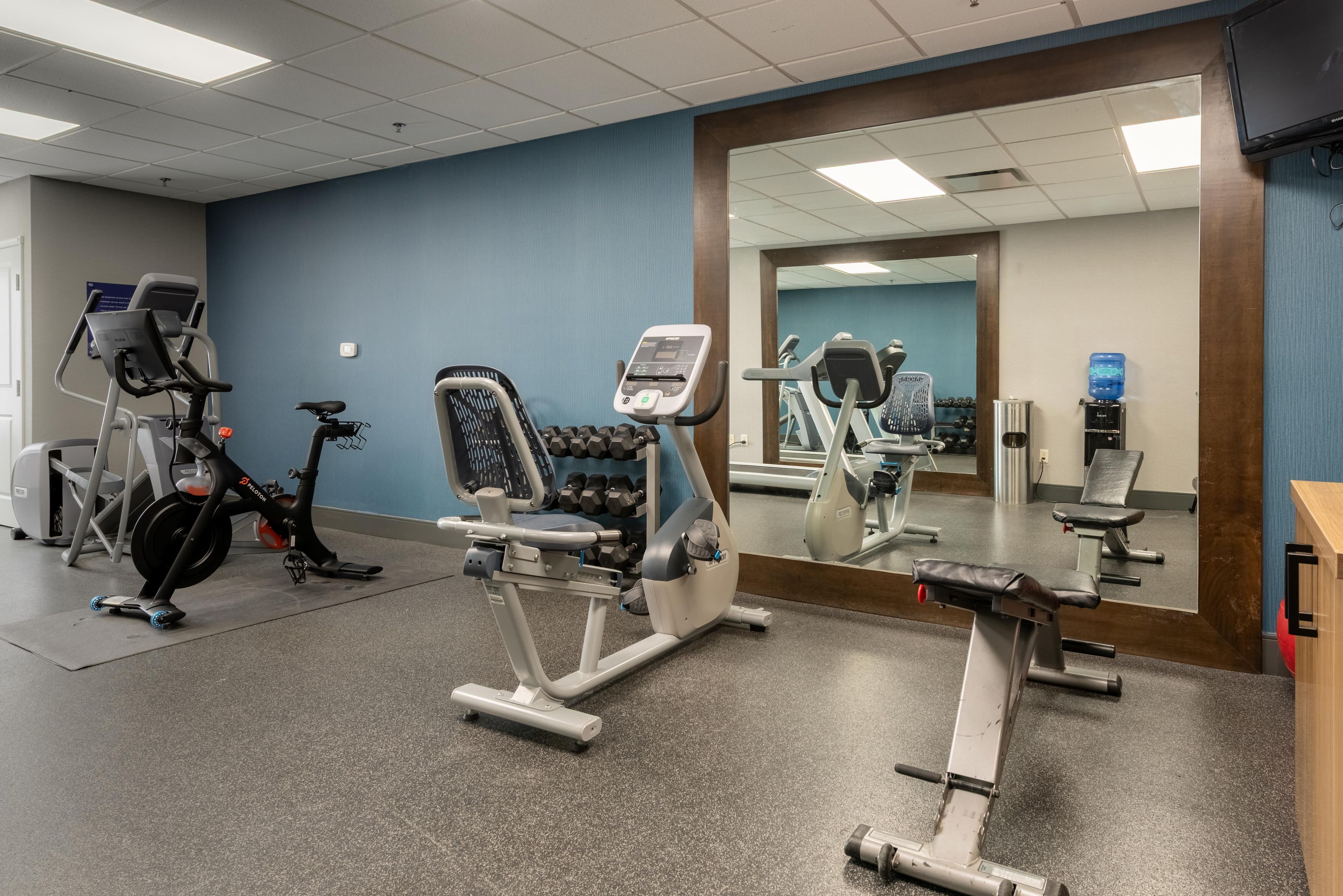 A gym with various exercise equipment, including treadmills, a stationary bike, and weight machines.