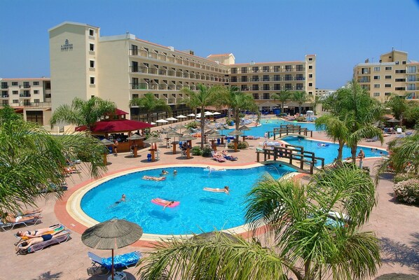 A hotel with multiple swimming pools, sun loungers, and palm trees. - Tsokkos Gardens Hotel (Paralimni)
