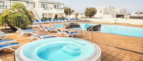 Alberca al aire libre, alberca en la azotea y sombrillas en la alberca